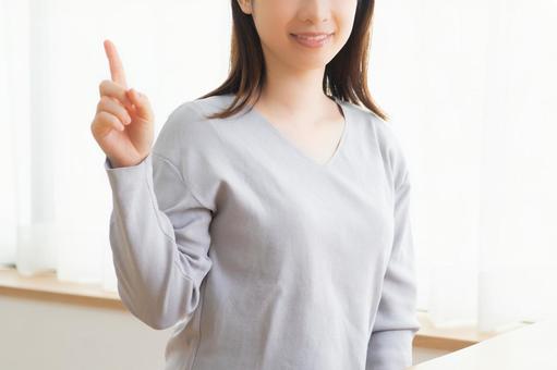 人差し指を立てている女性
